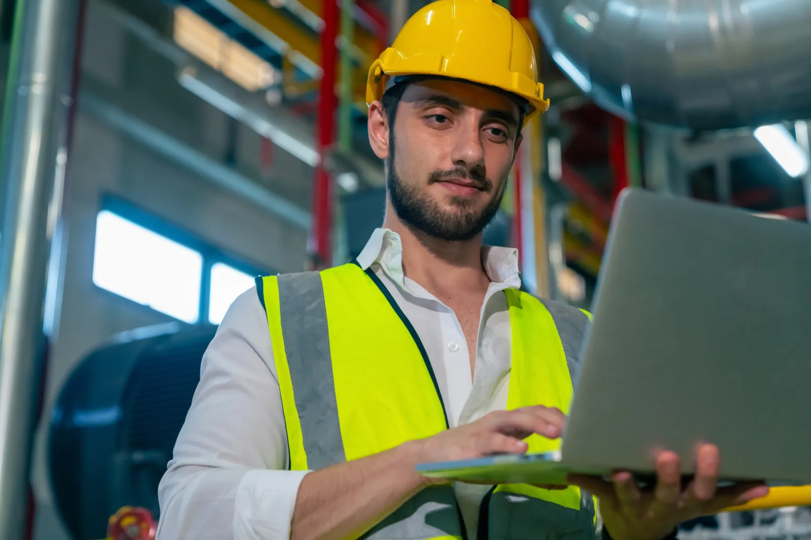 Electrical engineer working on a laptop at an industrial site